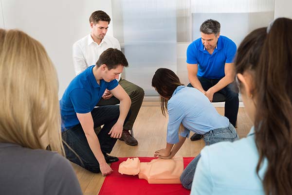 woman performing CPR on a dummy