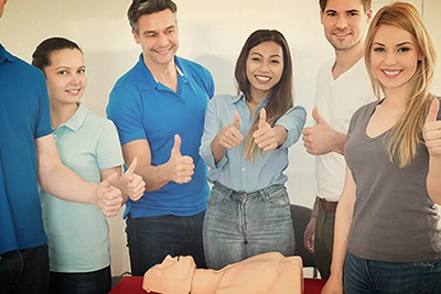 group of smiling people standing around a dummy